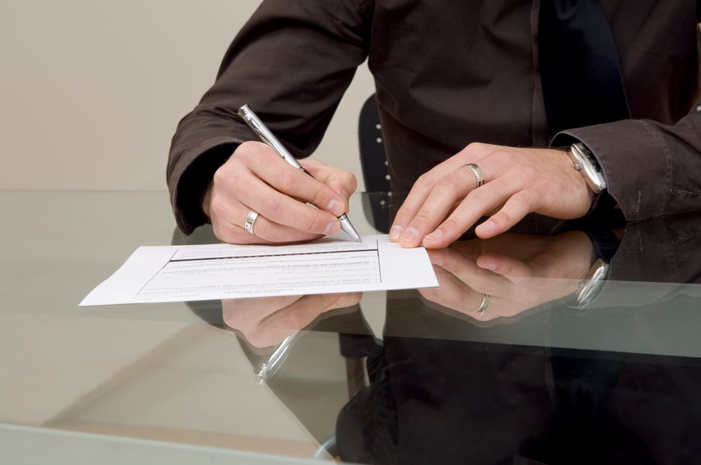 Businessman filling out paperwork.